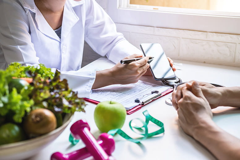 Doctor showing phone to patient while discussing weight loss options