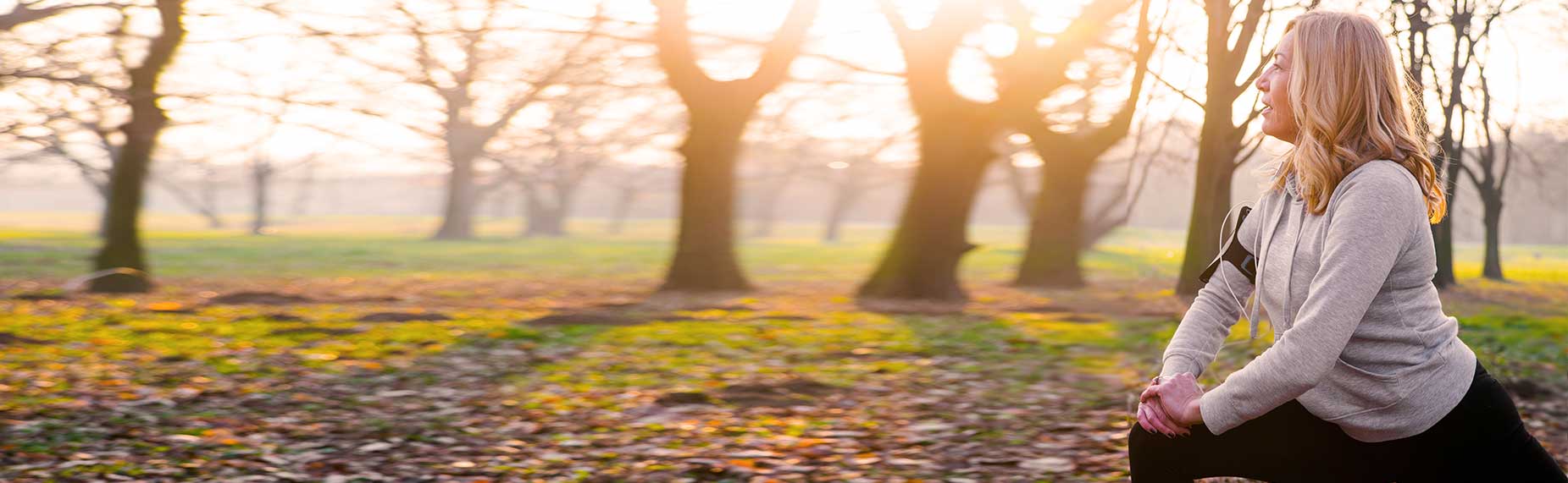 Mature woman exercising in park, stretching