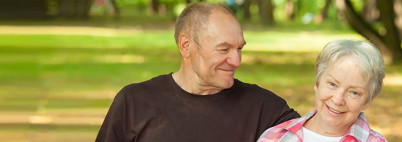 Older couple sitting on bench in a park during spring