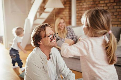 Close up of a father with glasses playing with his kids