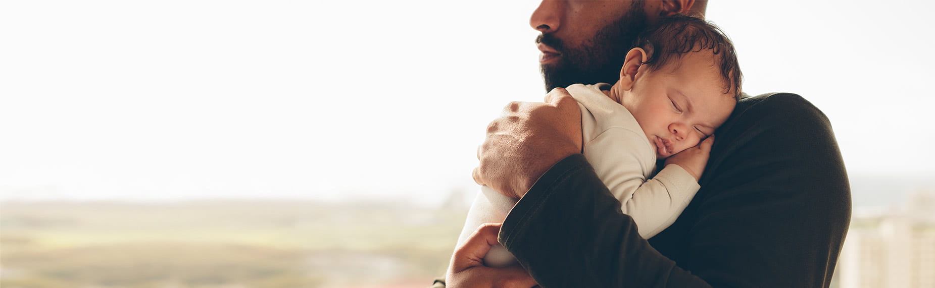 Newborn baby boy in his father's arms