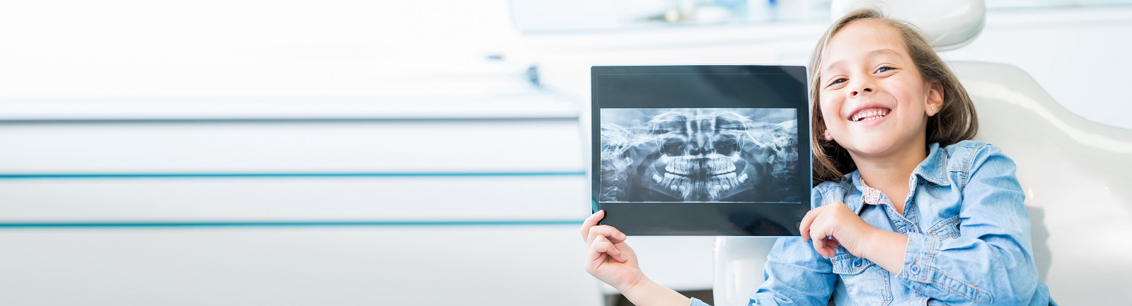 A smiling girl with her dentistry x-ray