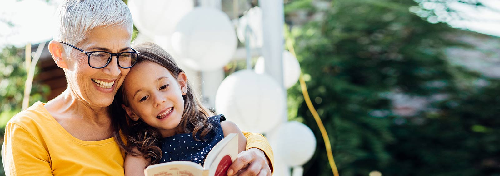 Grandmother celebrating a successful robotic surgery procedure by reading a book to her granddaughter