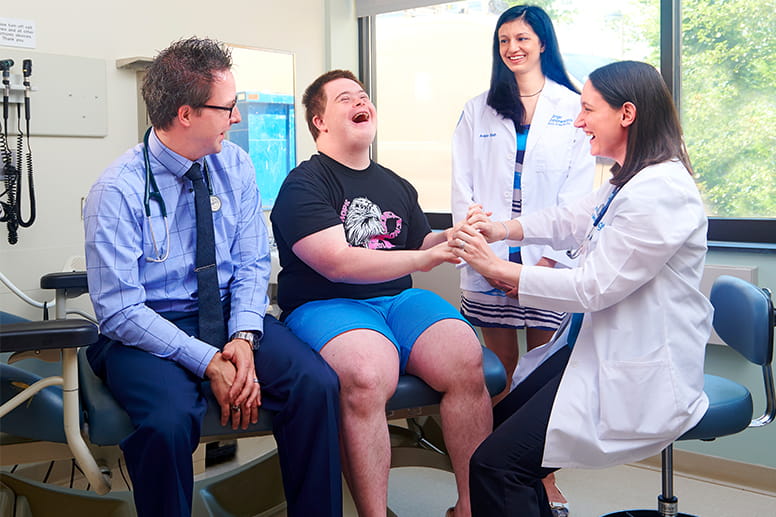 Thomas Davis, MD, and Geisinger Commonwealth student Avisha Shah look on as Michelle Cornacchia, MD, interacts with patient Adam Strouse in the Comprehensive Care Clinic.