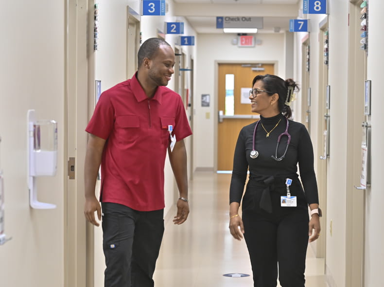 two medical staff members walking down a hospital hallway
