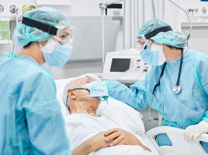 Man in hospital bed with doctors.