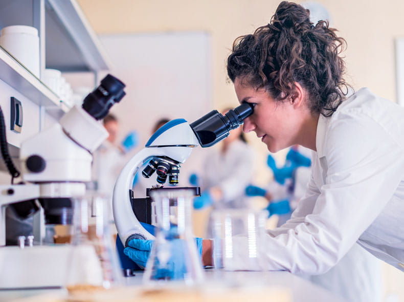 Woman looking into microscope.