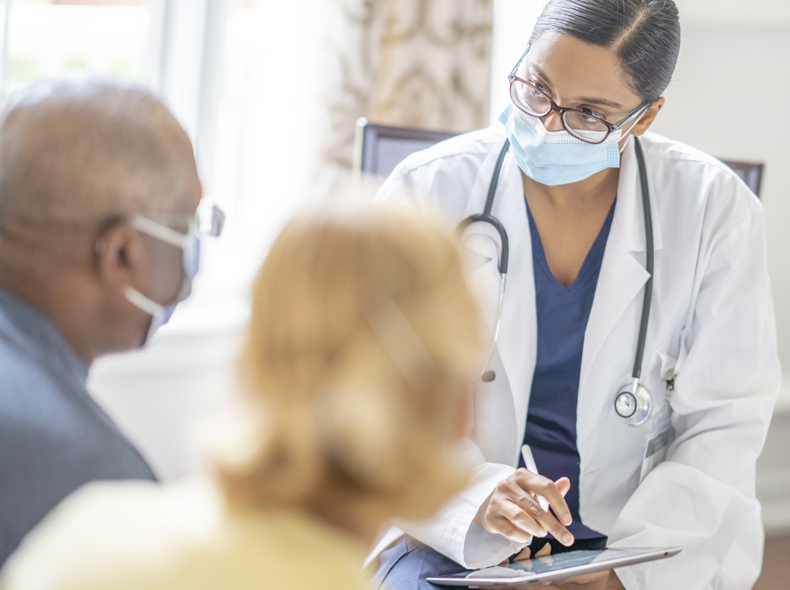 Doctor speaking with two people. 
