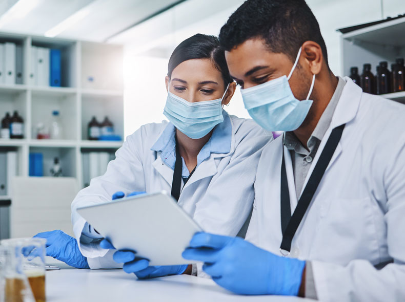 Two doctors look at a tablet