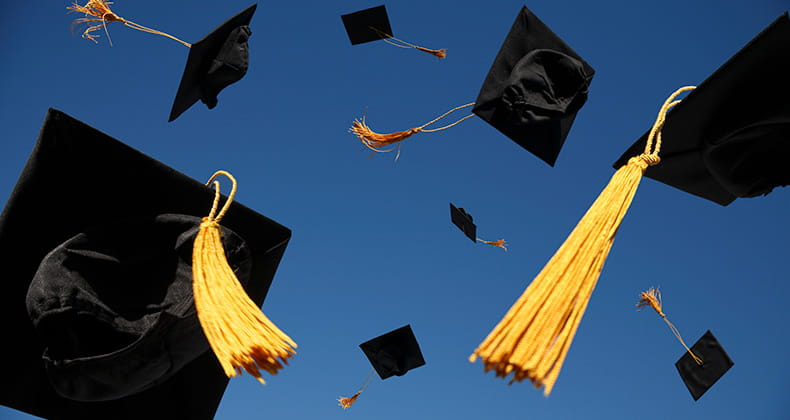 graduate caps flying through the air