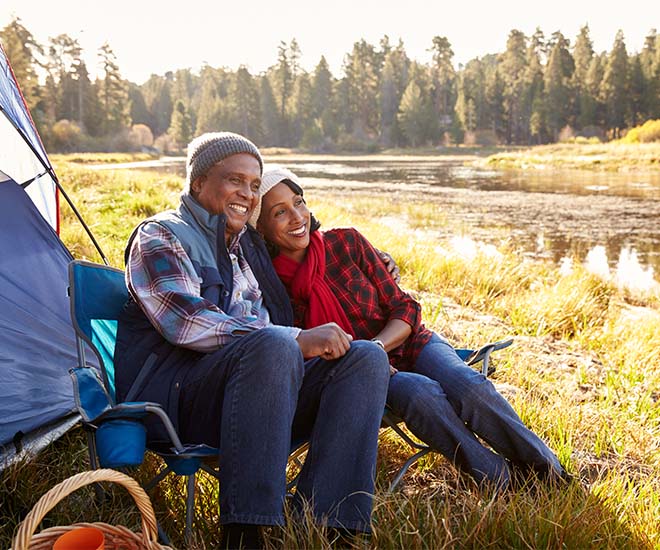 couple sitting outside their tent happy and smiling