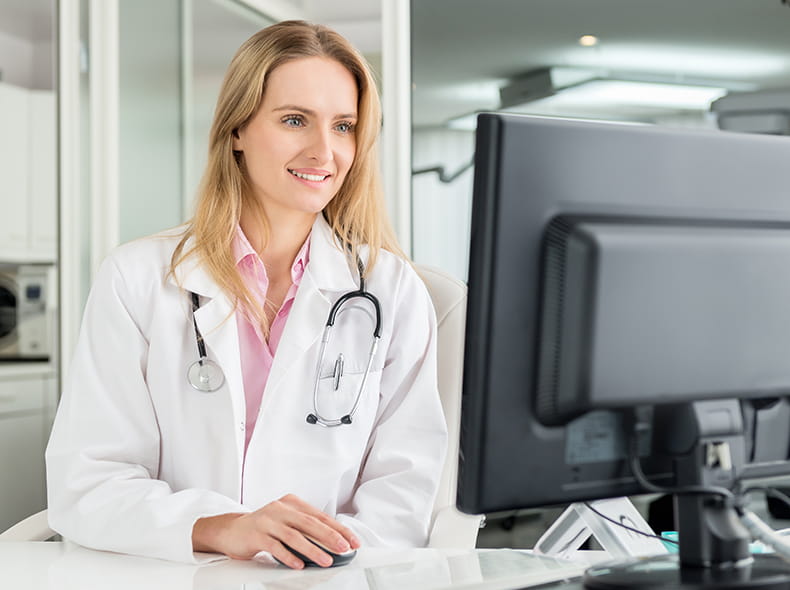 A smiling woman wearing a headscarf interacts with a man in glasses, seated in a modern, bright room.