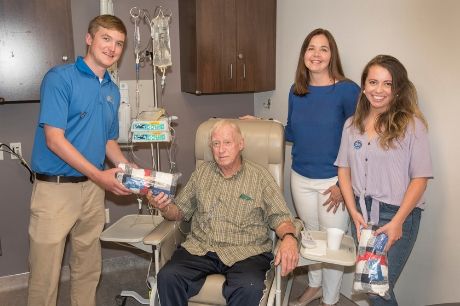 Joe Mushow receives a blanket from Subaru and the Leukemia and Lymphoma Society 