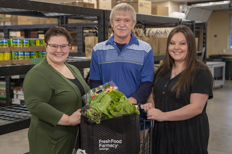 an image of two people holding a bag of groceries and smiling