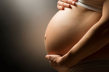 Pregnant woman holding belly