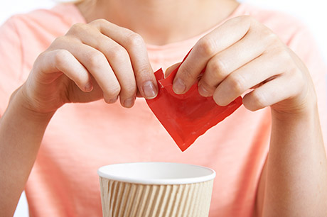 Women opening sugar packet