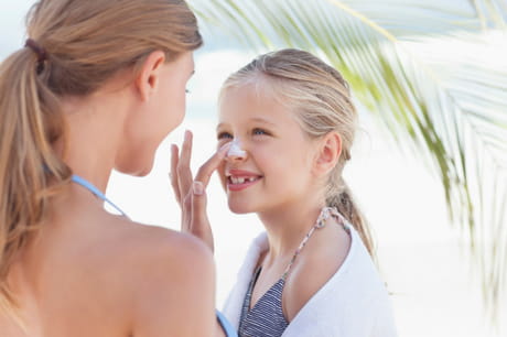 Woman putting sunscreen on a girl