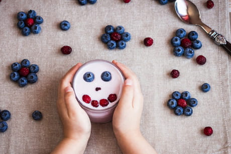 Child holding cup of yogurt