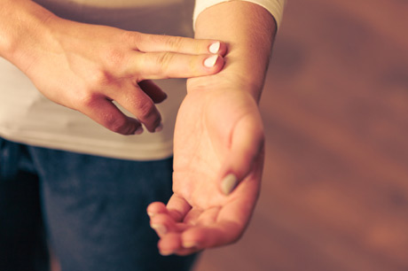 Woman testing her pulse to check for irregular heartbeat.
