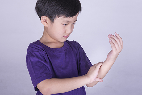 Boy looking at his wrist.