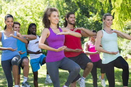 A group of individuals practice balancing poses.