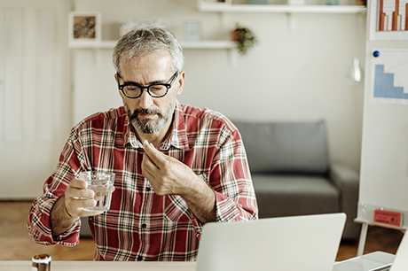 Man taking an aspirin at home