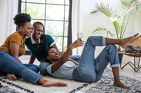 Three young women smiling and taking a photo together.