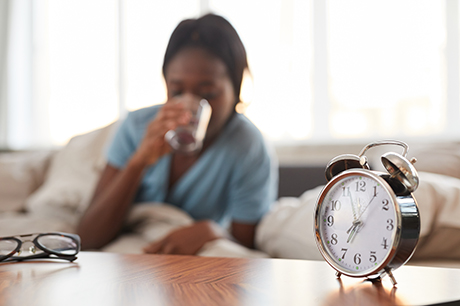 Woman waking up and drinking water