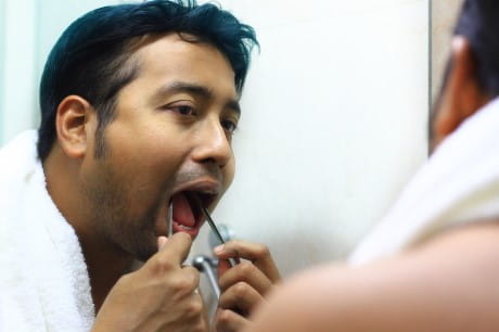 A man examining his tongue