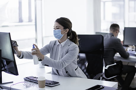an image of a lady cleaning her office computer