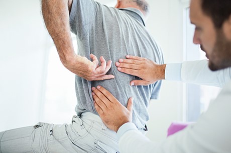 doctor examining sciatica pain patient