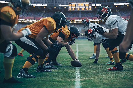 Young adults playing football in a stadium.