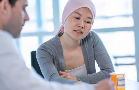 A female patient speaks to the oncology pharmacist regarding her prescription.