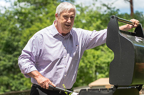 A man is preparing to grill outside.