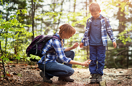 Woman spraying insect repellent on child.