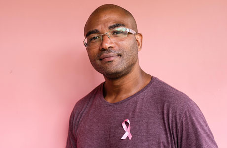 A man wearing a breast cancer ribbon. 