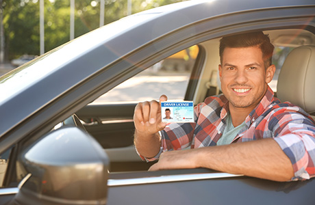 Man in car showing his donor card.