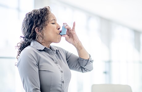 Woman using inhaler. 