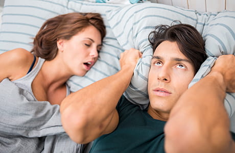 Man cannot sleep because his wife has sleep apnea.