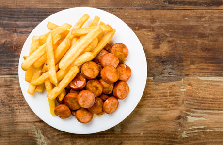 A plate of sausage and French fries