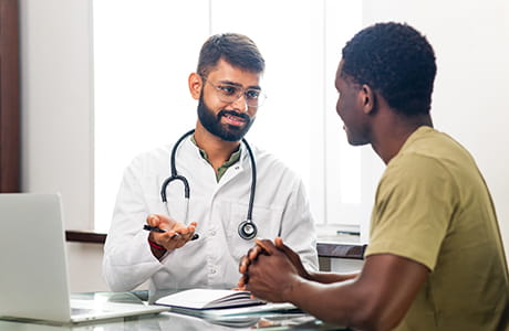 A male doctor talking to a male patient