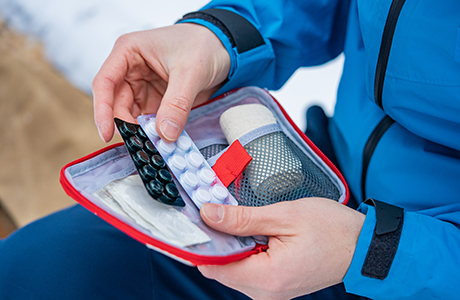 First aid kit containing pills, bandages, and other medical supplies.