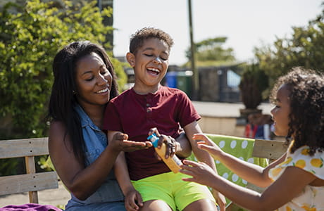 A family playing outside and putting on sunblock.