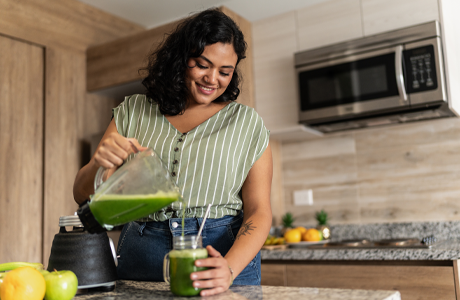 A woman making a healthy drink to help with her PCOS