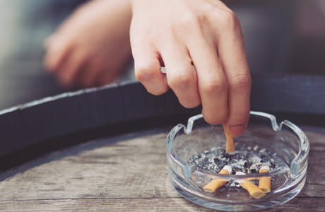 A cigarette being put out in an ash tray.