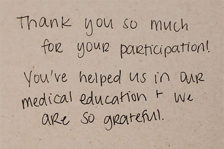Handwritten thank-you note for participation in medical education on a beige background.