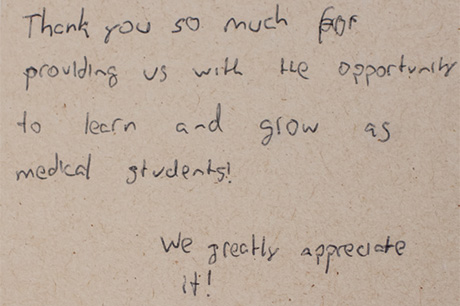 Handwritten thank-you note for participation in medical education on a beige background.